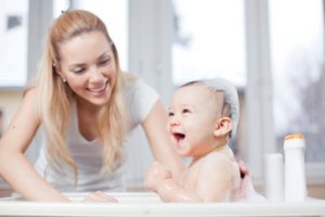 woman bathing baby - Plumbing, sewer, & drain services in Peoria IL