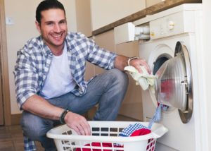 man doing laundry - Plumbing, sewer, & drain services in Peoria IL