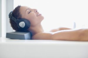 Woman in bathtub listening to music - Plumbing, sewer, & drain services in Peoria IL