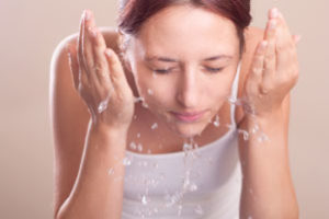Woman washing face - Plumbing, sewer, & drain services in Peoria IL